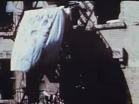 Hanging laundry on fire escapes between brick apartment buildings.