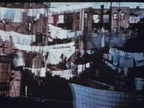 Dense urban view of tenement buildings with hanging laundry.
