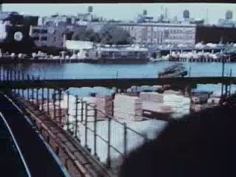 View of a river and bridge from a moving elevated train.