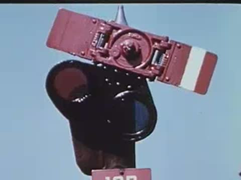 Close-up of a red and white railway signal with numbered plate.