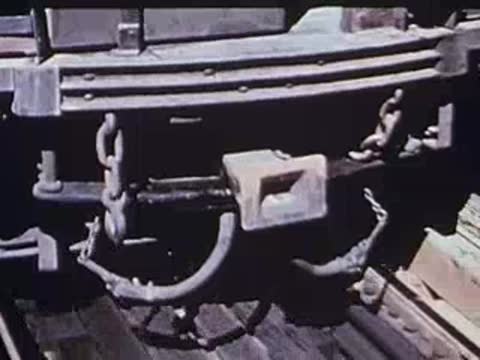 Close-up of train undercarriage wheels and mechanical linkages moving on tracks.