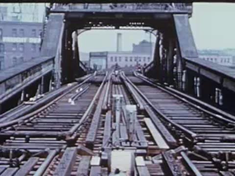 Forward tracking shot from elevated train approaching a bridge structure.
