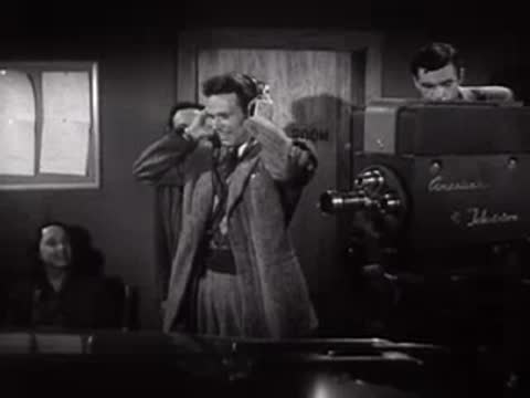 Studio crew members adjusting equipment and wearing headphones on set.