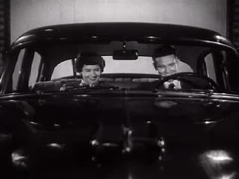 Couple sitting inside the car on the studio soundstage.
