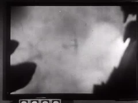Monitor screen showing smoky, rocky landscape or explosion footage.