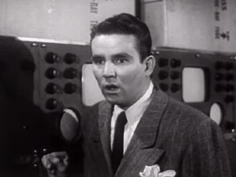 Man in suit speaking urgently in a laboratory setting.