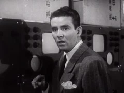 Man in suit talking and looking towards the side in a laboratory.