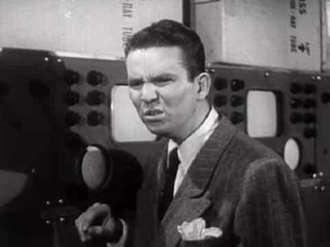 Man in suit reacting with a grimace or confusion in a laboratory.