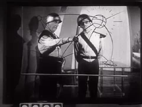 Two people in futuristic uniforms with an overlaid geometric diagram on screen.