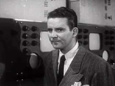 Man in suit smiling slightly while looking towards the side.