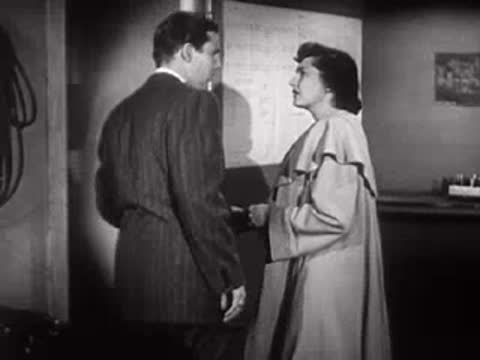 A man walks away and leaves an office while a woman watches.