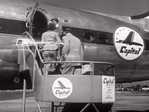 Passengers board a Capital Airlines propeller plane, then view of parked plane.