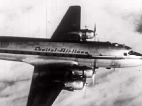 A Capital Airlines propeller airplane flies through clouds in the sky.