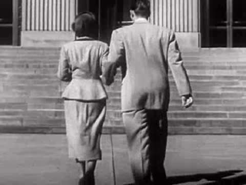 A couple walks away together down outdoor steps, mid-century fashion.