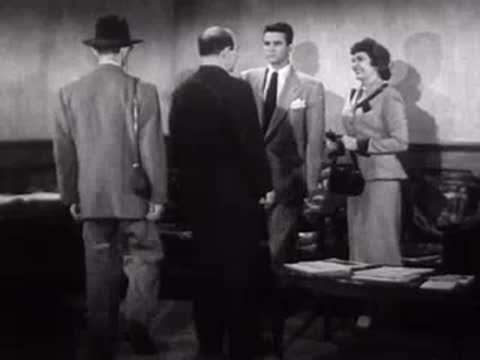 Men walking over to greet a woman inside a building.