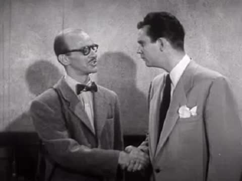 Two men shaking hands inside a building.