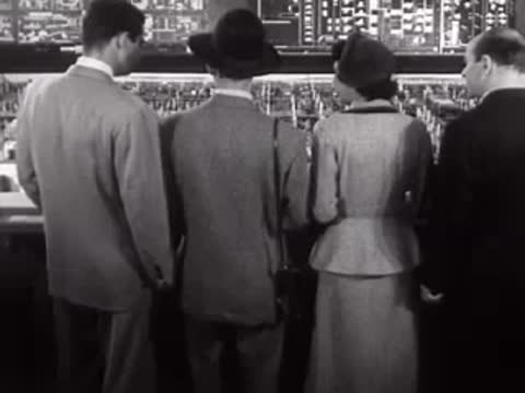 People viewed from behind looking at an industrial model display.