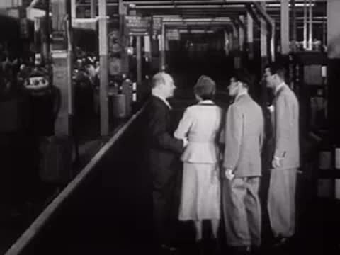 People walking and gathering in an industrial workspace.