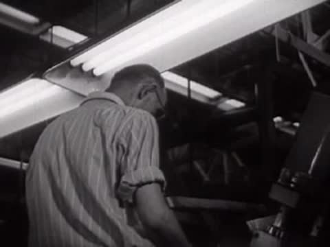 A worker operating machinery inside a factory.