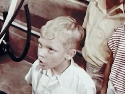 Children watching intently inside a dairy barn.