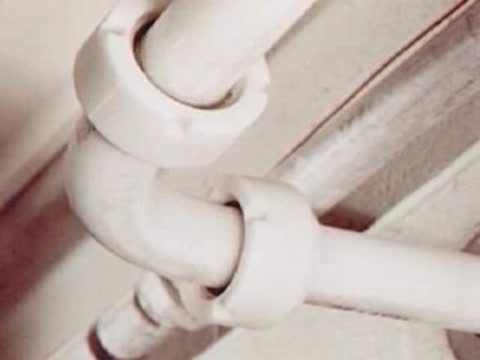 Close-up of white plumbing pipes and valves inside a dairy facility.