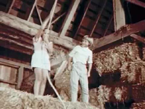 Children standing in a hayloft near a rope