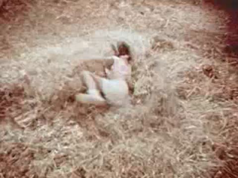 Child jumping into hay in a loft