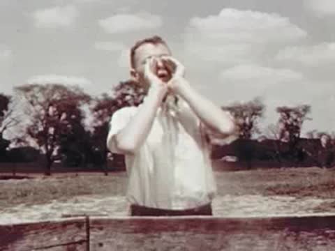 Man in a light shirt cupping hands around mouth calling out.