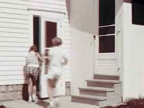 Child running towards a white screen door of a house.