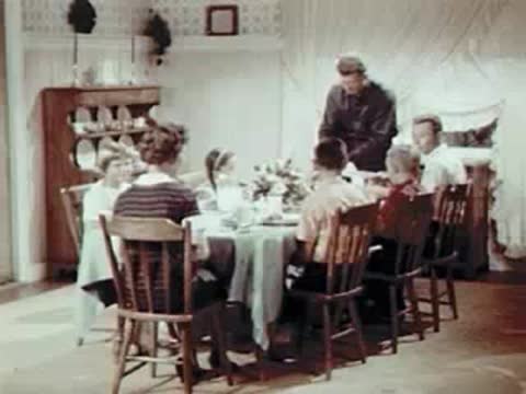 Family seated around a dining table for a meal.