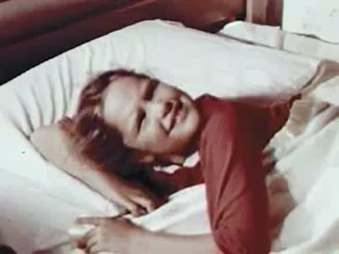 Child waking up smiling in bed, mid-century setting