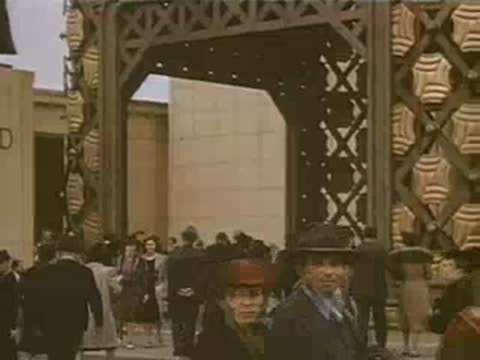 A medium shot of the POLAND pavilion entrance with people walking around.