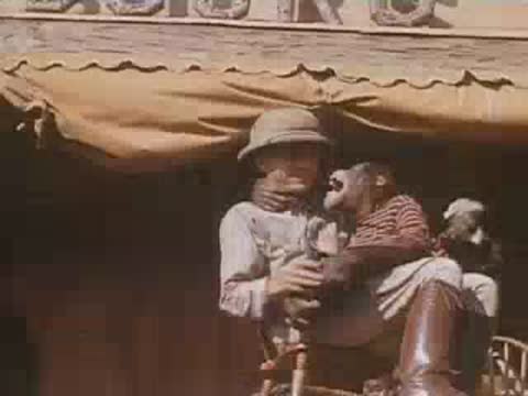 A man in safari gear hugs a chimpanzee on stage at Jungleland.