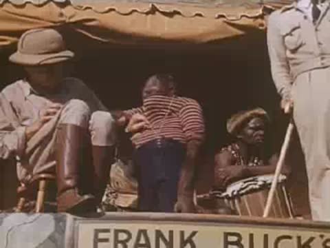 Safari guide sits with a chimpanzee on stage during a Jungleland performance.
