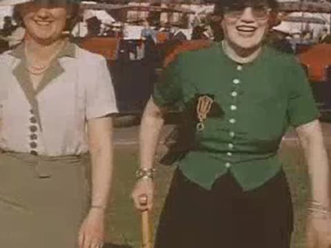 Two smiling women walking together on the fairgrounds pathway