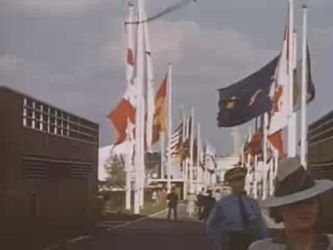 Lined flagpoles marking a pathway between modern architectural walls