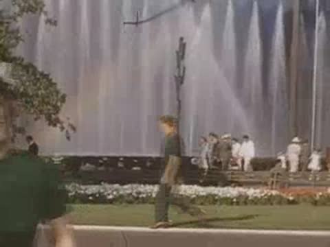 Woman in a green dress smiling near the fair fountain area
