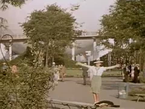Woman raising her arms happily on a sunny park pathway