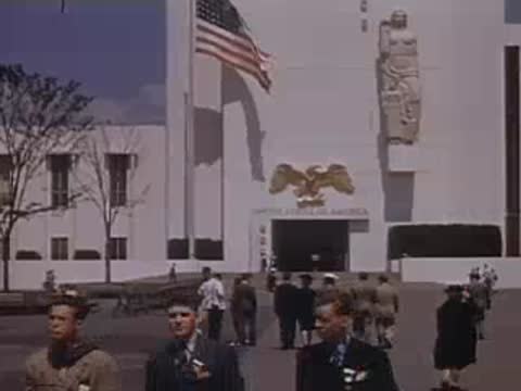 American flag waving on a pole outside the USA pavilion building