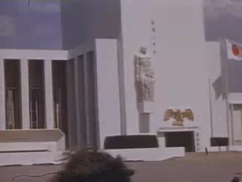 Medium tracking shot past the columns and statues of the United States federal building.