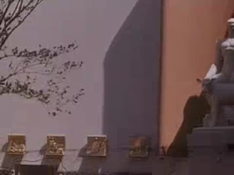 Medium shot of a white animal statue and decorative plaques on a building wall.