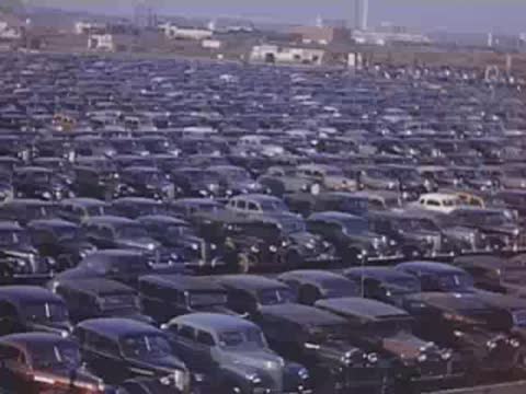 Wide shot across dense rows of parked cars in the expansive fair parking lot.