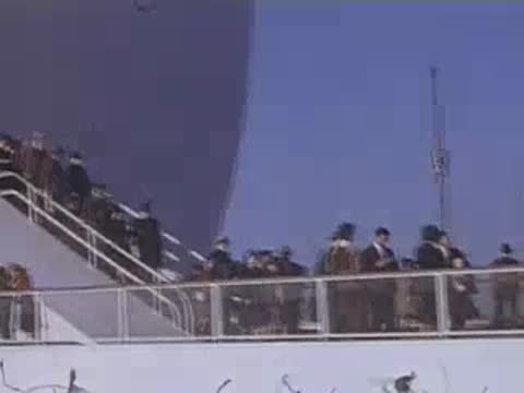 Crowds of visitors walking up the exterior ramp and stairs of the white spherical Perisphere pavilion.