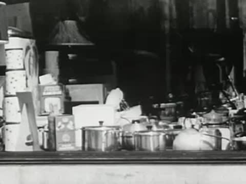 Store window display filled with pots, pans, and housewares
