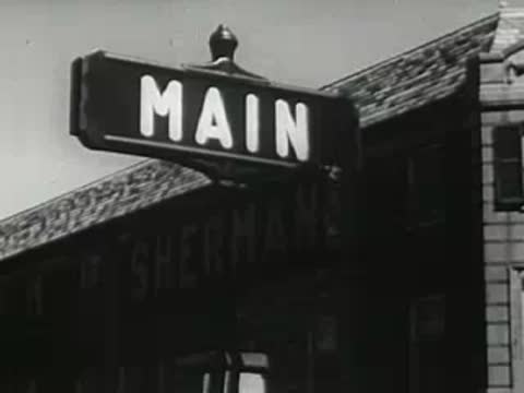 Main Street sign panning down to 1940s town buildings
