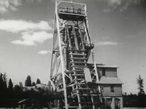Industrial mine head frame or tower against cloudy sky