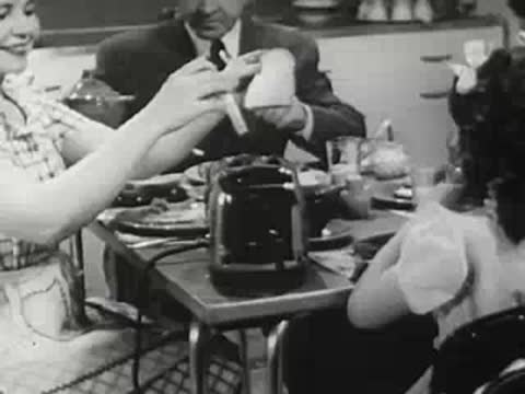 Family having breakfast together at kitchen table, 1940s style