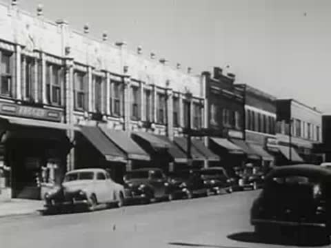Panning shot along Main Street with parked vintage cars and storefronts