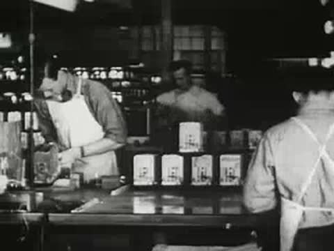 Factory workers assembling and handling toasters on an assembly line, historical footage.