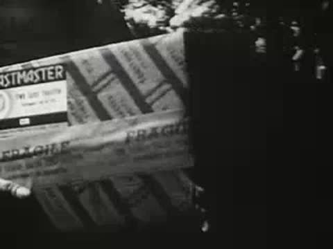 Close-up of a packaged box labeled 'Toastmaster' being handled in a warehouse.